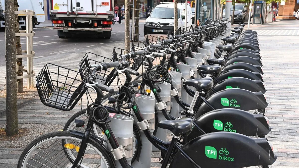 Orderly row of green TFI public bicycles docked securely in off-street terminal bays